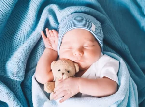 Baby snuggling a teddy bear sleeping peacefully